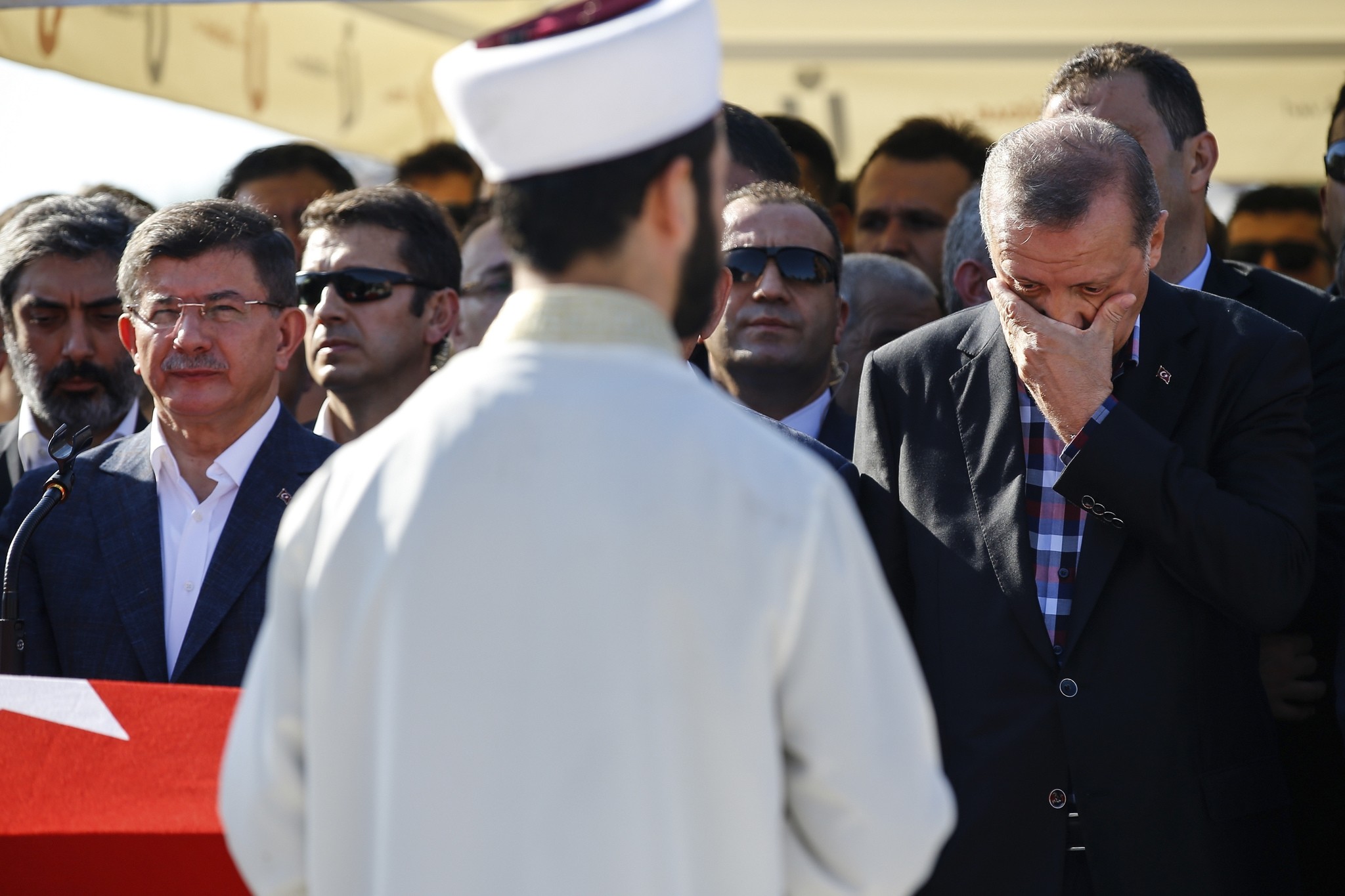 Turkish President Recep Tayyip Erdogan right, wipes his tears during the funeral of Mustafa Cambaz, Erol and Abdullah Olcak. 