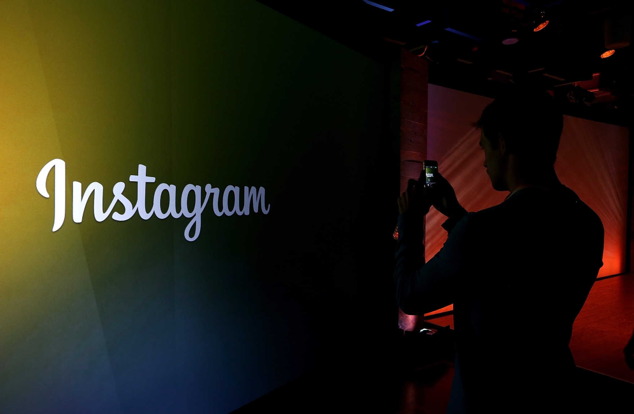 This file photo taken on June 19, 2013 shows an attendee takeing a photo of the instagram logo during a press event at Facebook headquarters in Menlo Park, California. (AFP Photo)