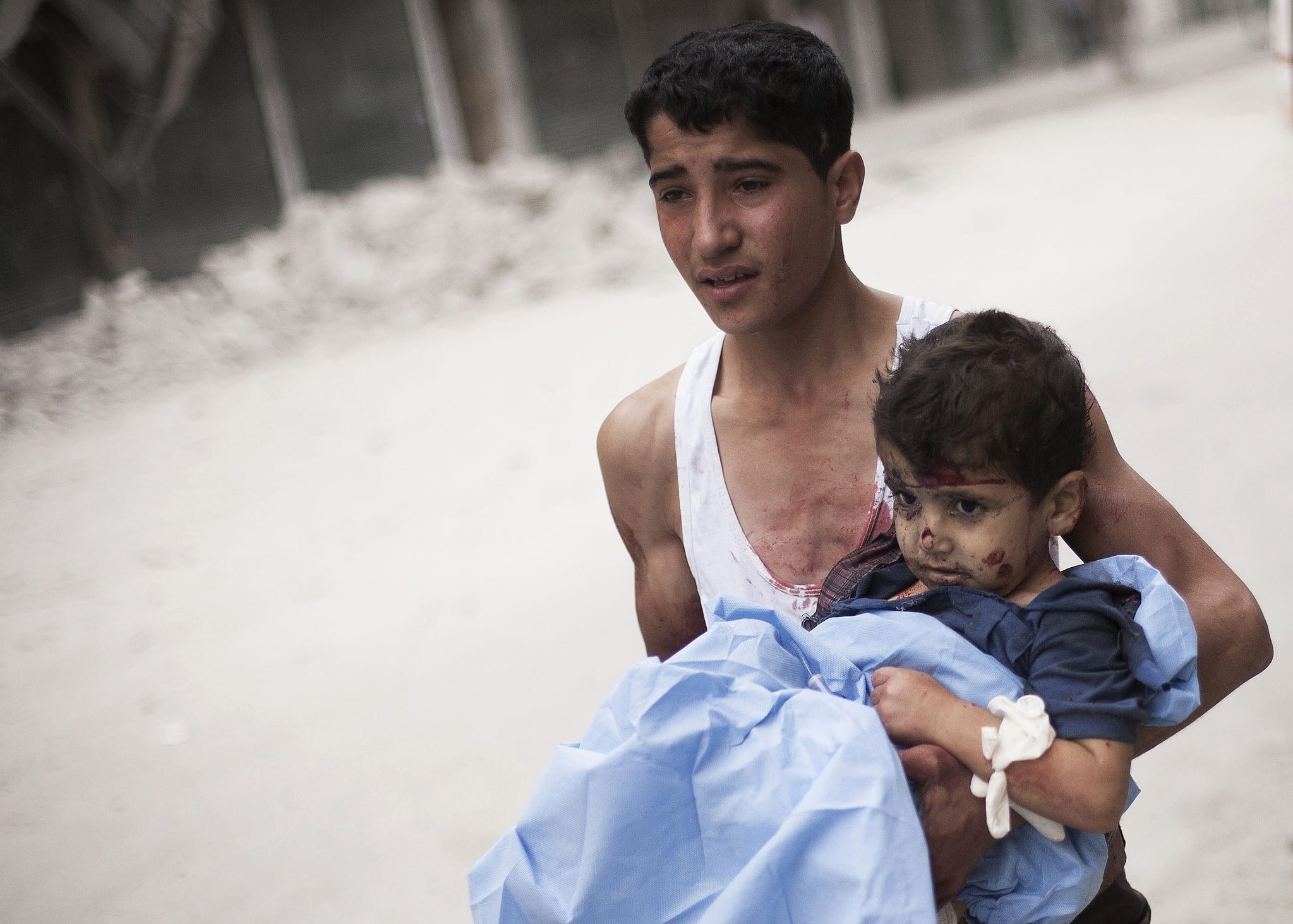 A Syrian youth holds a child wounded by Syrian Army shelling near Dar El Shifa hospital in Aleppo, Syria, Thursday, Oct. 11, 2012. (AP Photo)