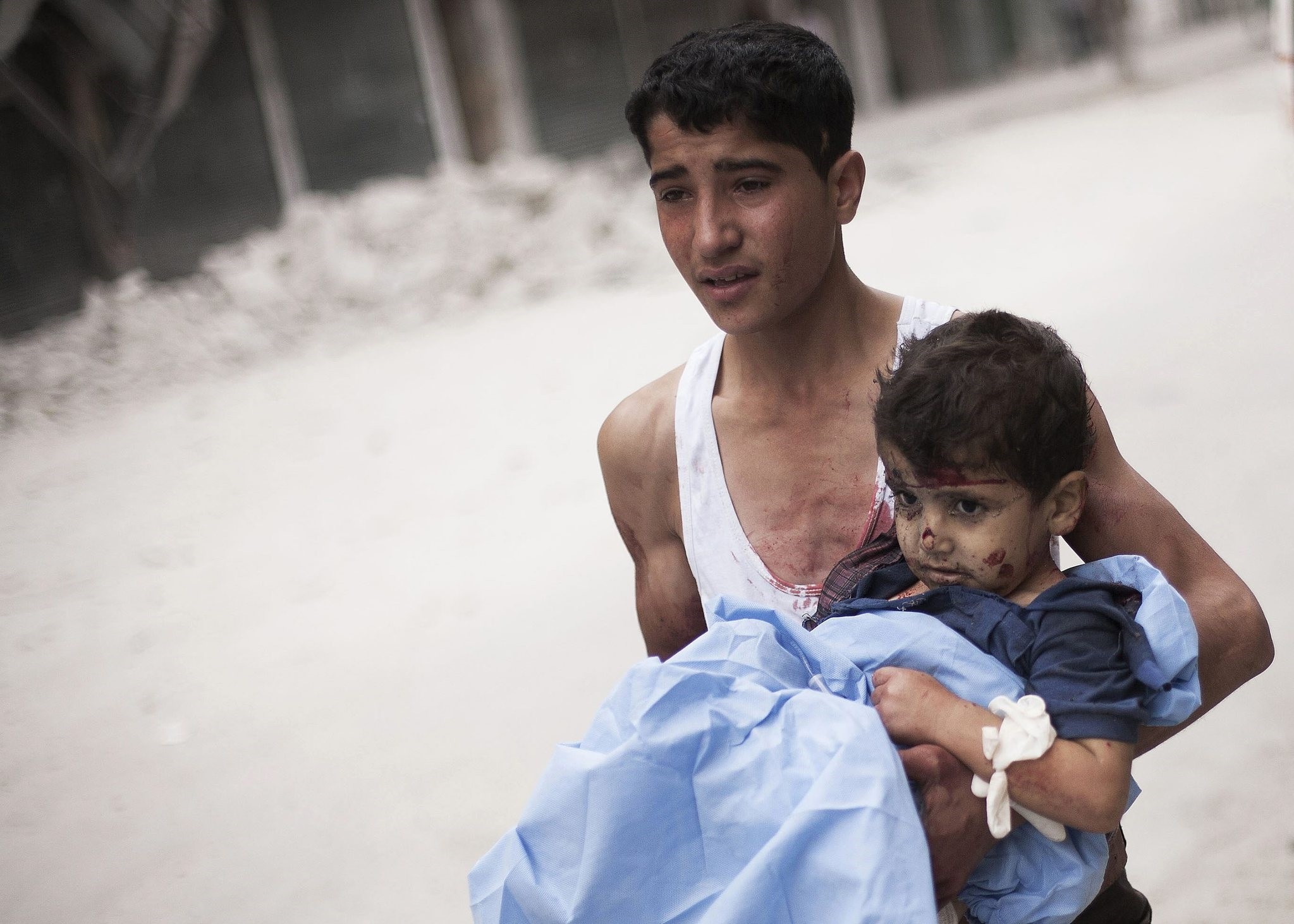 A Syrian youth holds a child wounded by Syrian Army shelling near Dar El Shifa hospital in Aleppo, Syria, Thursday, Oct. 11, 2012. (AP Photo)