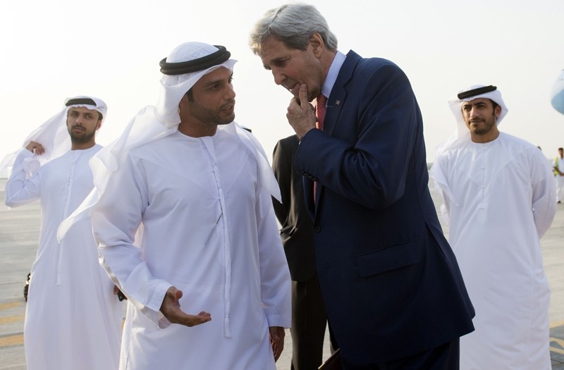 UAE Protocol Chief Shihab Al Faheem (centre L) seen in a traditional Emirati kandoorah, talks with U.S. Secretary of State John Kerry.  AFP PHOTO