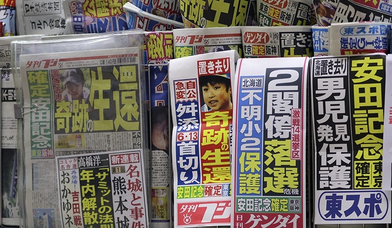 An image of Yamato Tanooka, the missing 7-year-old Japanese boy, is displayed by Japanese newspaper Yukan Fuji being sold at a railway station kiosk in Tokyo (AP Photo)