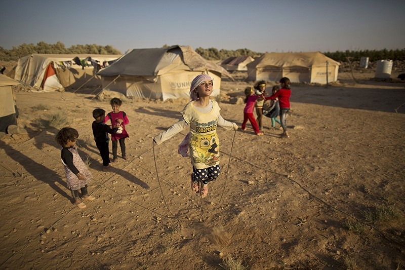Syrian refugee girl, Zubaida Faisal, 10, skips a rope while she and other children play near their tents at an informal tented settlement near the Syrian border on the outskirts of Mafraq, Jordan, July 19, 2016. (AP Photo)
