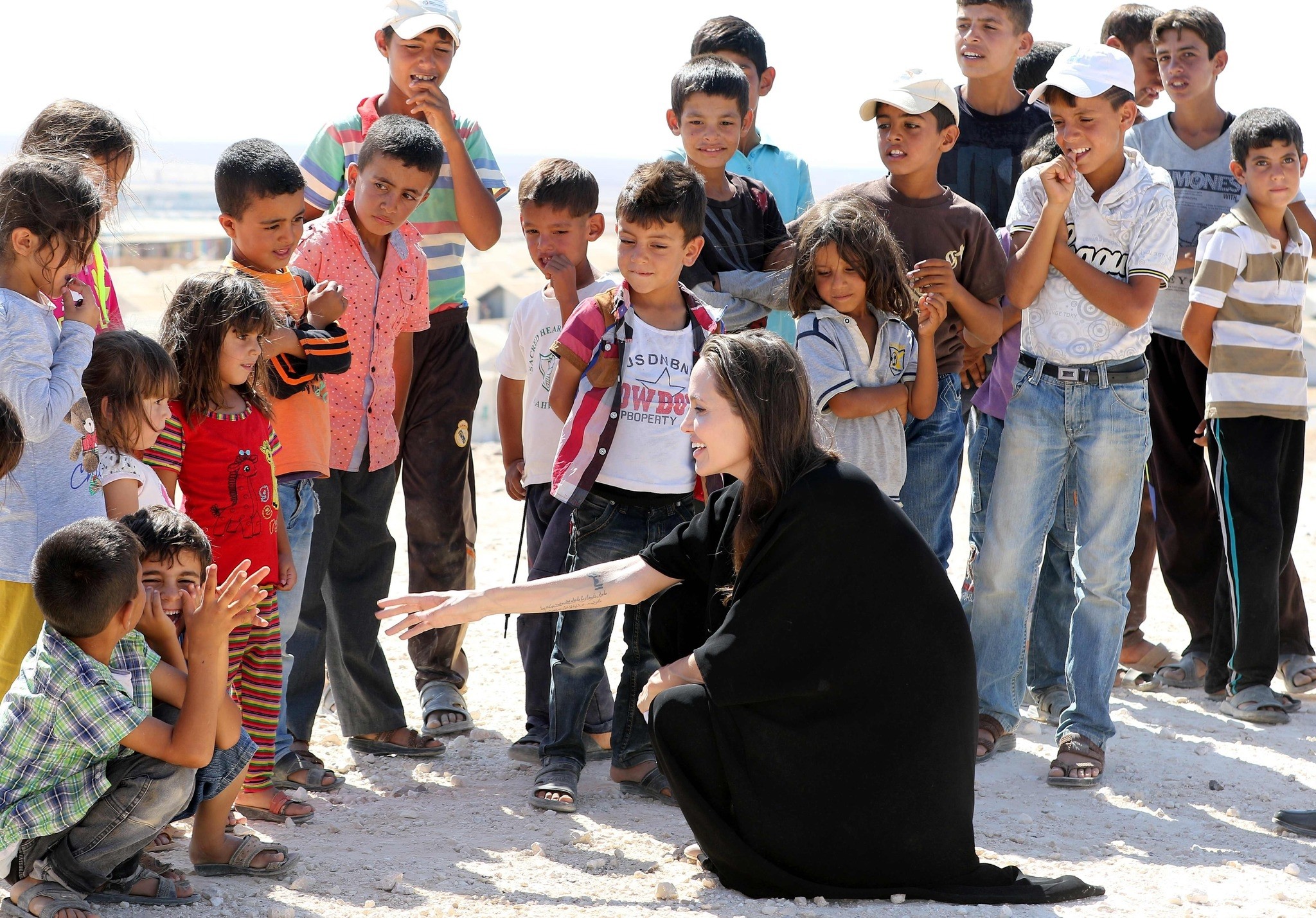 US actress and UNHCR special envoy Angelina Jolie (C) talks to children during a visit to a Syrian refugee camp in Azraq in northern Jordan, on September 9, 2016. (AFP PHOTO)