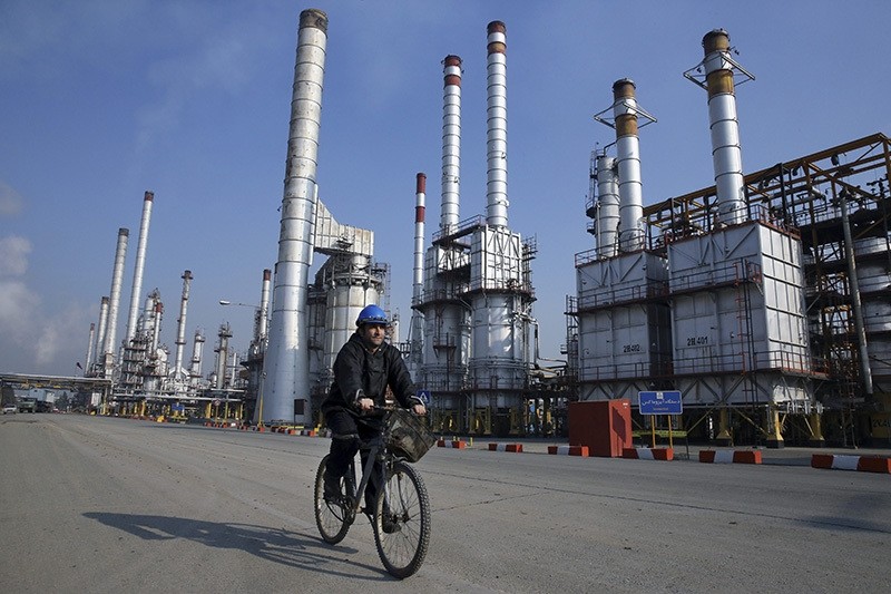 In this Dec. 22, 2014 file photo, an Iranian oil worker rides his bicycle at the Tehran oil refinery, south of the capital Tehran, Iran. (AP Photo)