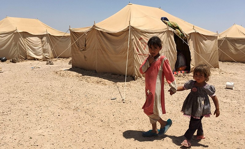 Displaced Iraqi children stand outside a tent at a newly-opened camp in the government-held town of Amriyat al-Fallujah 50 kilometres (30 miles) southwest of Baghdad, on May 29, 2016 (AFP Photo)