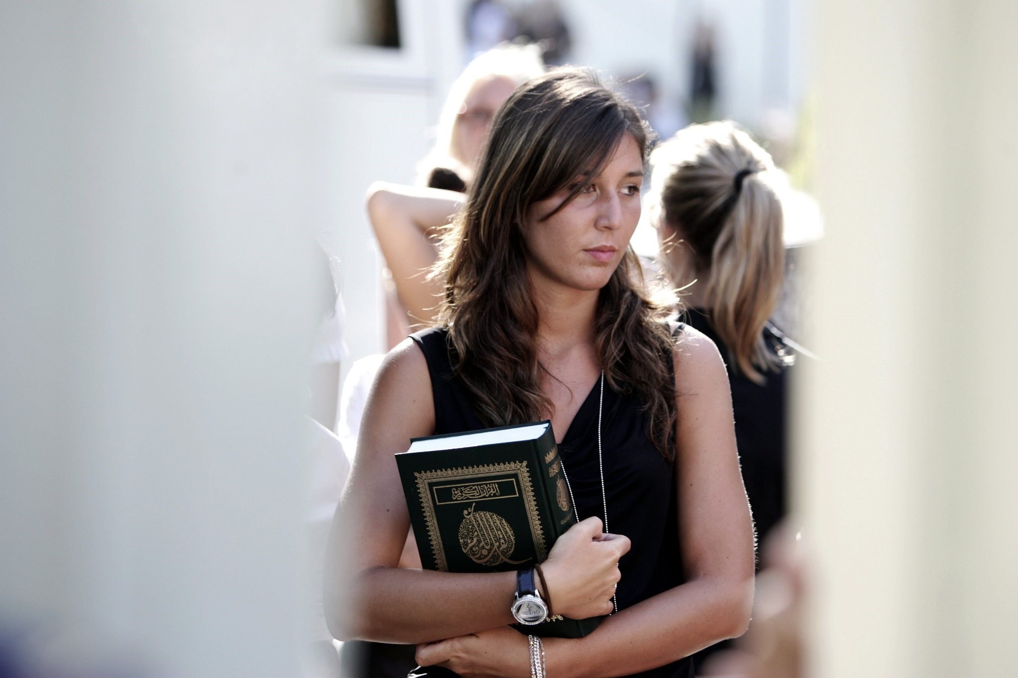 A  woman holds a copy of the Koran after a meeting with Libyan leader Moammar Gadhafi, at the Libyan Academy near the Libyan ambassador's residence in Rome, Sunday, Aug. 29, 2010. (AP Photo) 