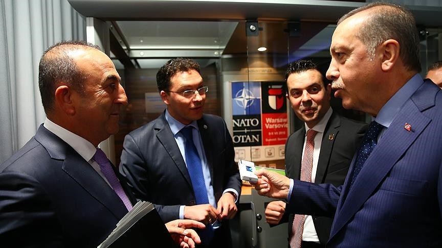 Turkish President Recep Tayyip Erdou011fan (R) speaks to Turkish FM Mevlu00fct u00c7avuu015fou011flu (L) while holding Bulgarian FM Daniel Mitov's (CL) cigarette pack. (AA Photo)