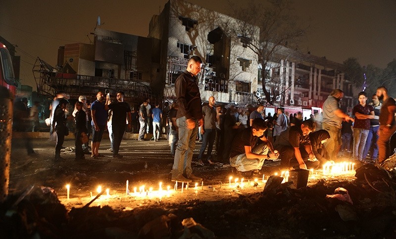 People light candles at the scene of a massive car bomb attack in Karada, a busy shopping district where people were shopping for the upcoming Eid al-Fitr holiday, in the center of Baghdad, Iraq (AP Photo)