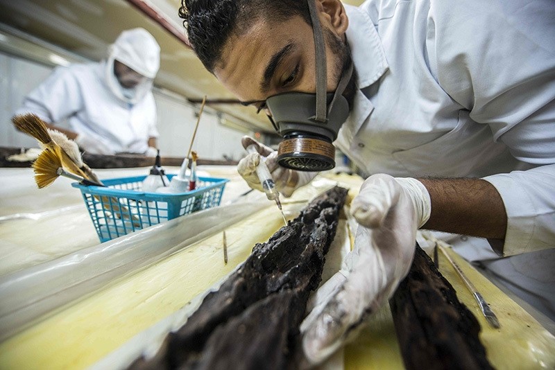 Egyptian archaeologist Mohamed Anwar works on parts of the second solar boat of Pharaoh Khufu on Aug 31, 2016 at the restoration laboratory, located behind the Great Pyramid of Cheops, on the southern outskirts of the capital Cairo. (AA Photo)