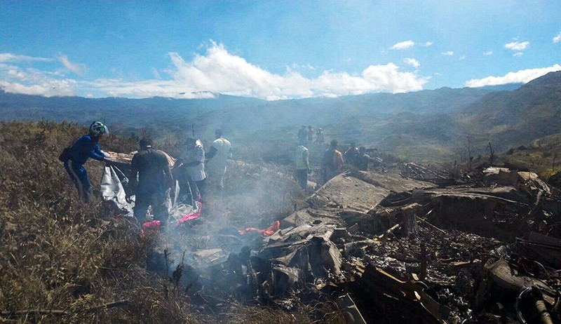Indonesian officials exame the Hercules military plane that crashed. (AFP Photo)