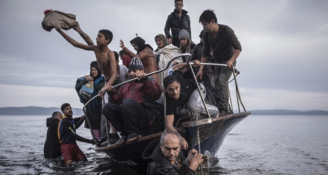 In this Nov. 1, 2015 photo by Sergey Ponomarev, migrants arrive by a Turkish boat near the village of Skala, on the Greek island of Lesbos. (AP Photo)
