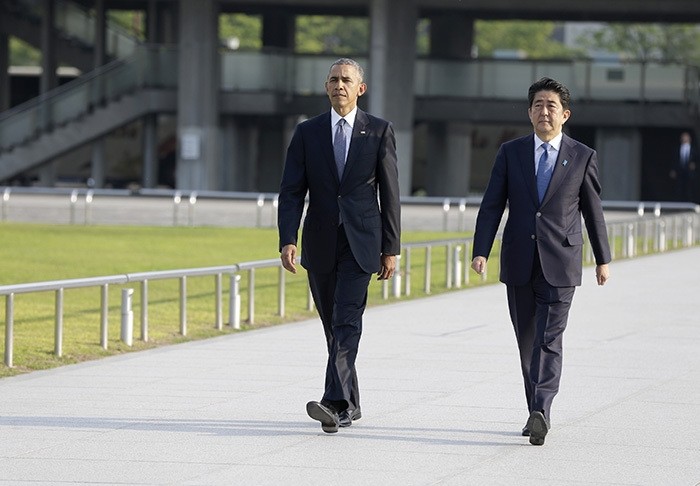 U.S. President Barack Obam, left, walks with Japanese Prime Minister Shinzo Abe for a wreath-laying ceremony at Hiroshima Peace Memorial Park in Hiroshima, western, Japan, Friday, May 27, 2016. (AP Photo)