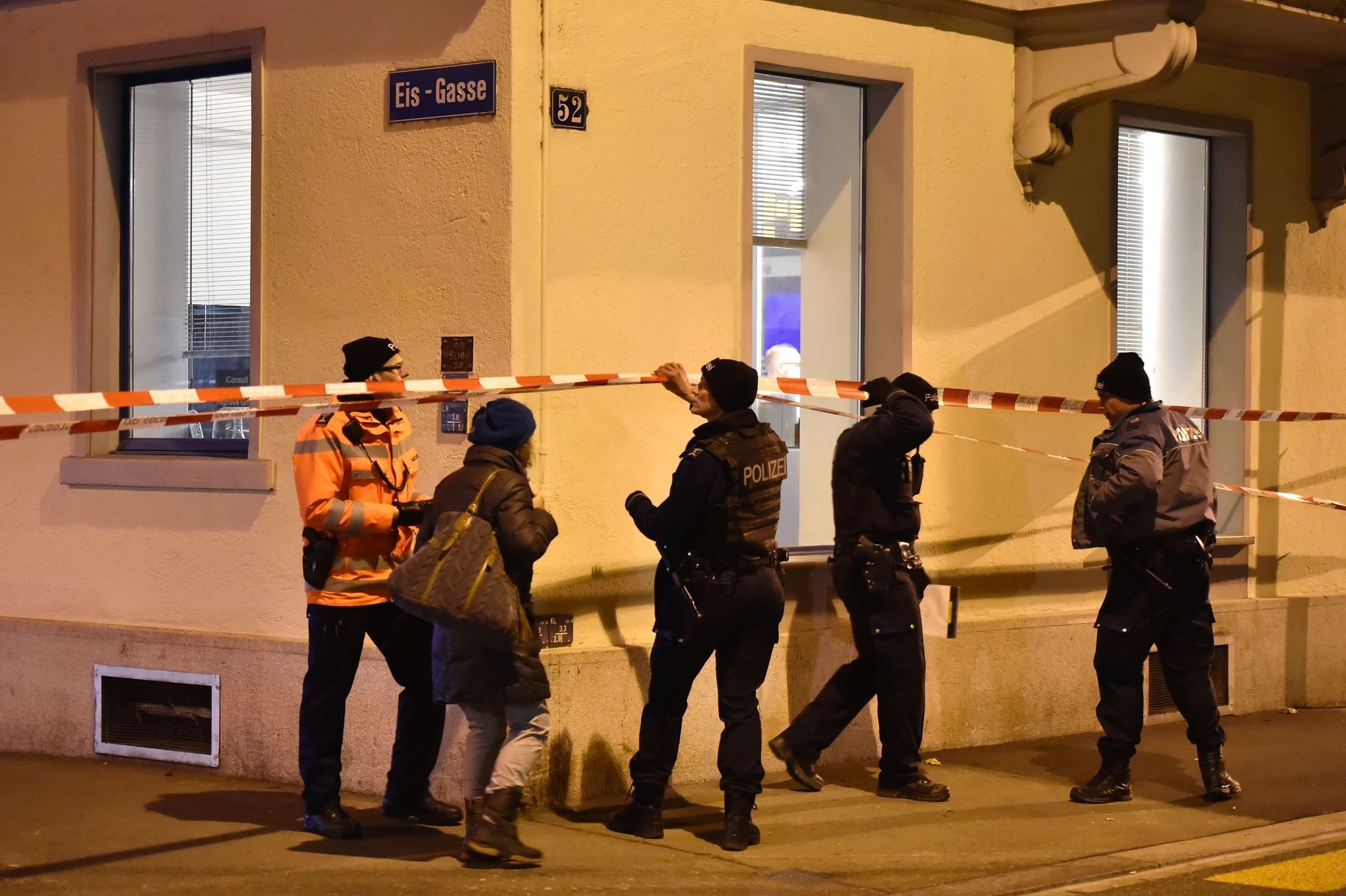 Swiss police walk behind a police cordon outside a Muslim prayer hall at the Eis-Gasse street, central Zurich, on December 19, 2016, after three people were injured by gunfire. (AFP Photo)