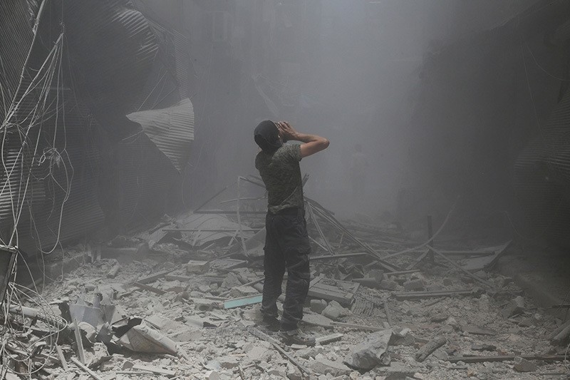 A Syrian man reacts following a reported air strike by Assad forces in the opposition-held neighbourhood of Bustan al-Qasr on June 5, 2016. (AFP)