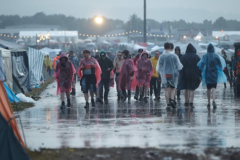 Visitors to the music festival Rock am Ring are seen during a heavy downpour in the west German city of Mendig on June 3, 2016. (AFP Photo)