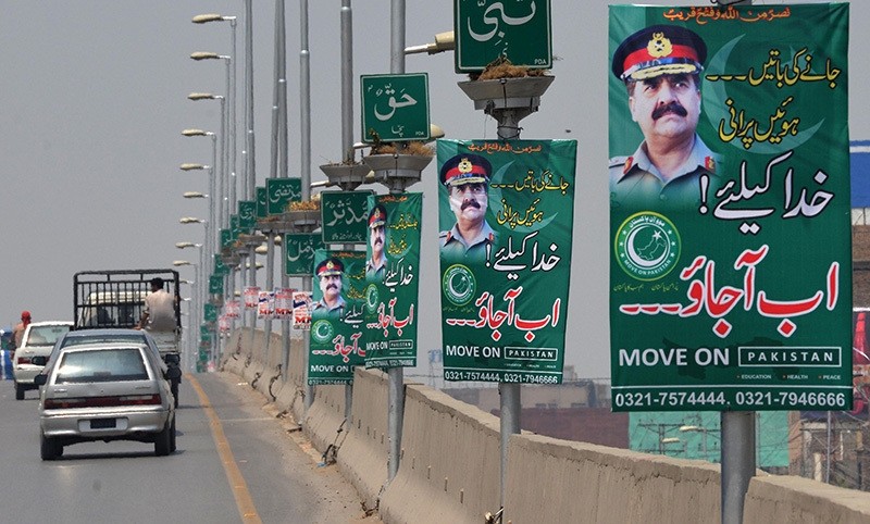 Pakistani commuters drive past posters of army chief General Raheel Sharif in Peshawar on July 12, 2016. (AFP Photo)