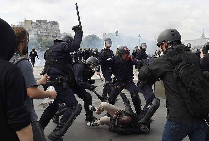 Police officers clash with a demonstrator near the Invalides during a protest against proposed labor reforms in Paris on June 14, 2016 (AFP).