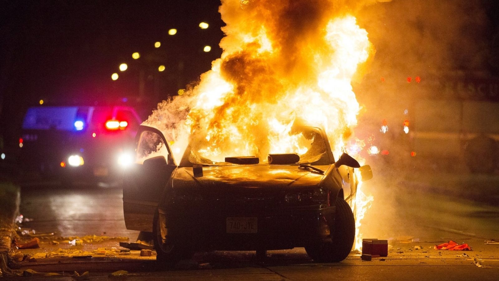A car burns as a crowd of more than 100 people gathers following the fatal shooting of a man in Milwaukee, Saturday, Aug. 13, 2016.  AP Photo