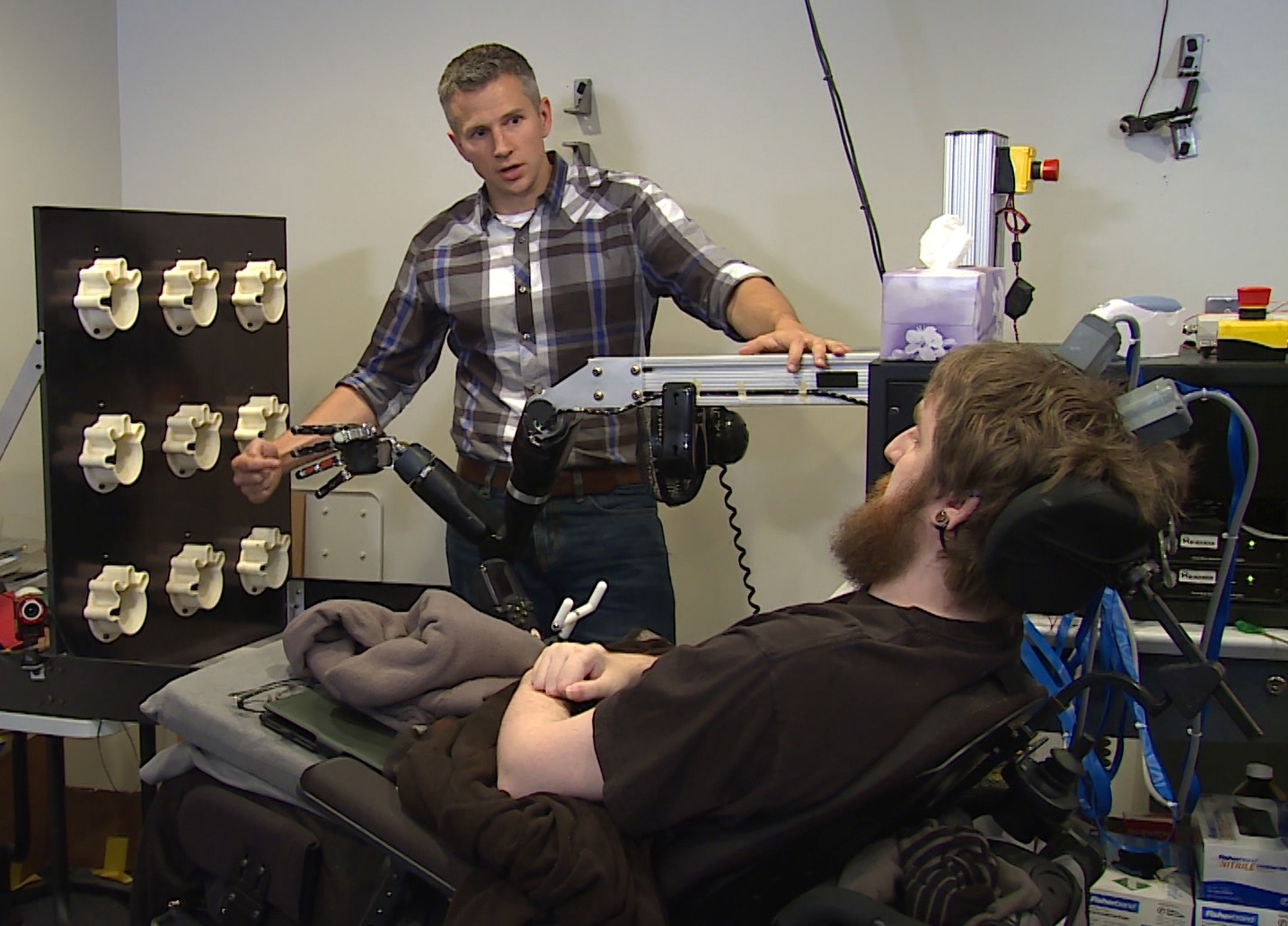 This image from video, provided by UPMC/Pitt Health Sciences, taken Oct. 26, 2015, shows University of Pittsburgh researcher Robert Gaunt preparing Nathan Copeland. (AP Photo) 