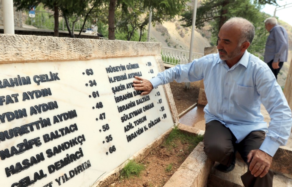 Locals visit a monument with the names of the victims.
