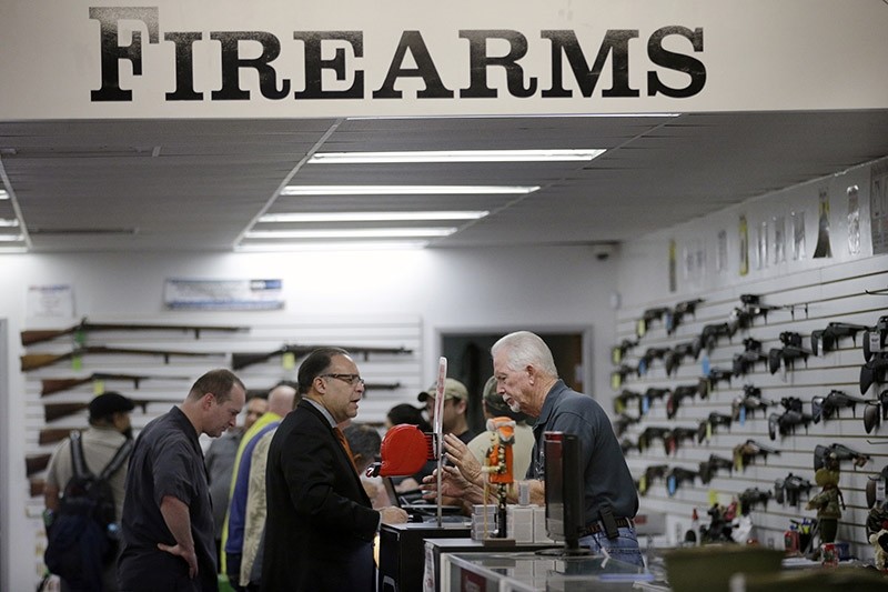 In this Dec. 9, 2015, file photo, sales associate Mike Conway, right, shows Paul Angulo guns at Bullseye Sport gun shop in Riverside, Calif. (AP Photo)