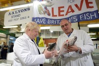 Former London Mayor Boris Johnson (L) with a worker as he visits Billingsgate Market, Britain's largest wholesale fish market, during a campaign event in London on Wednesday.