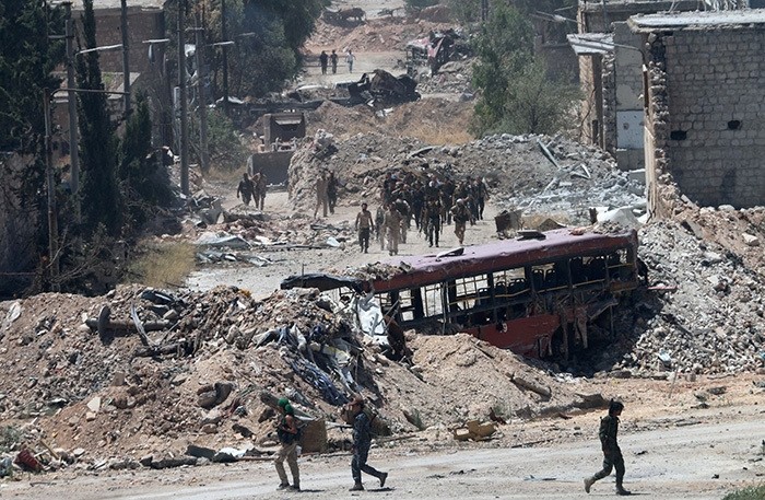 Syrian army soldiers patrol the area around the entrance of Bani Zeid after taking control of the previously rebel-held district of Leramun, on the northwest outskirts of Aleppo, on July 28, 2016. (AFP Photo)
