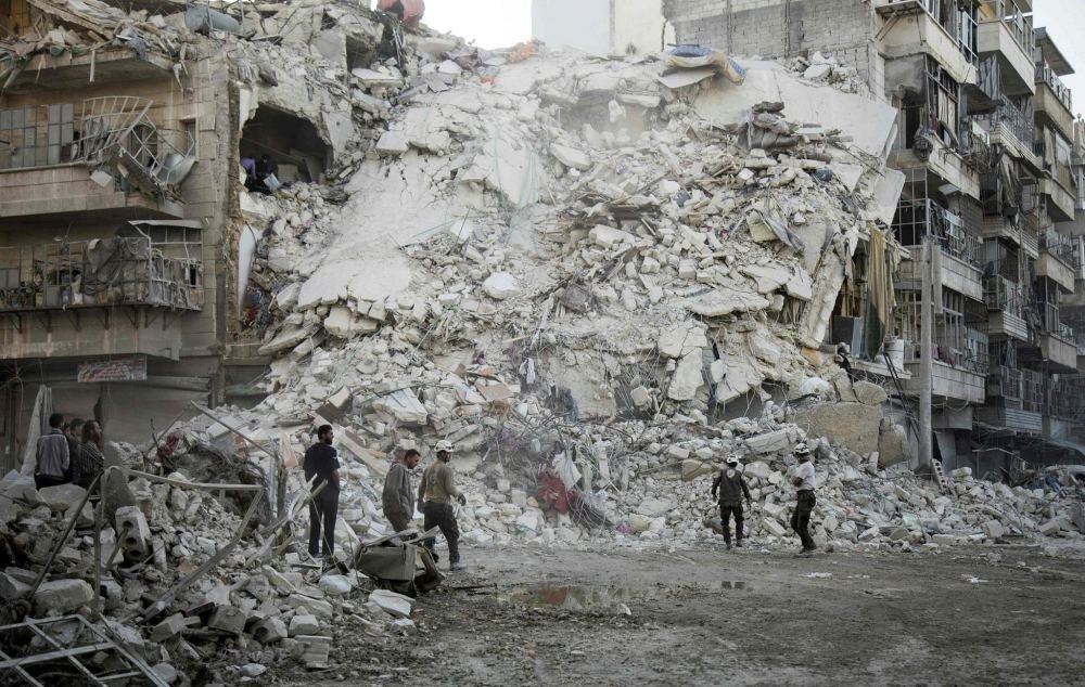 Members of the Syrian Civil Defense, known as the White Helmets, search for victims amid the rubble of a destroyed building following reported air strikes in the opposition-held Qatarji neighborhood of the northern city of Aleppo, on Oct. 17.