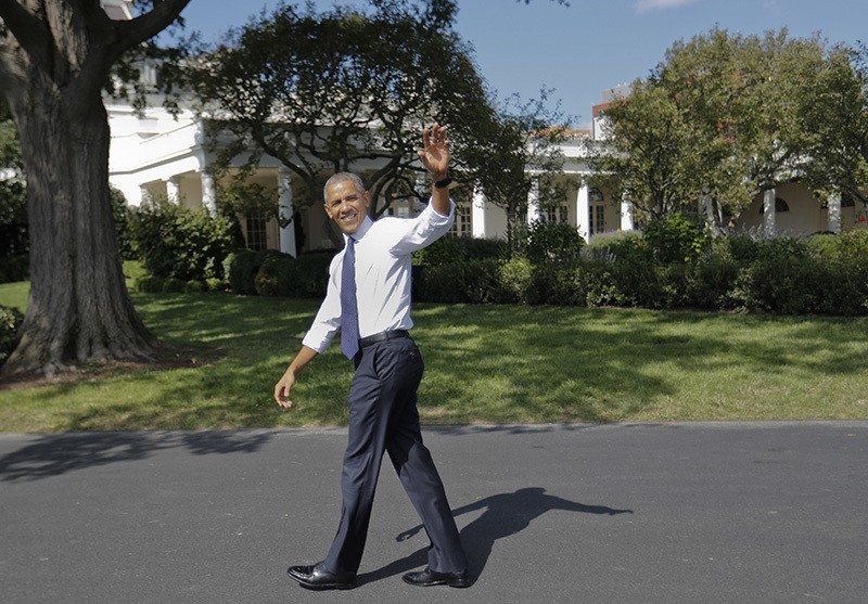President Barack Obama waves as he walks back to the Oval Office of the White House in Washington, Oct. 3, 2016, after surprising guests attending South by South Lawn. (AP Photo)
