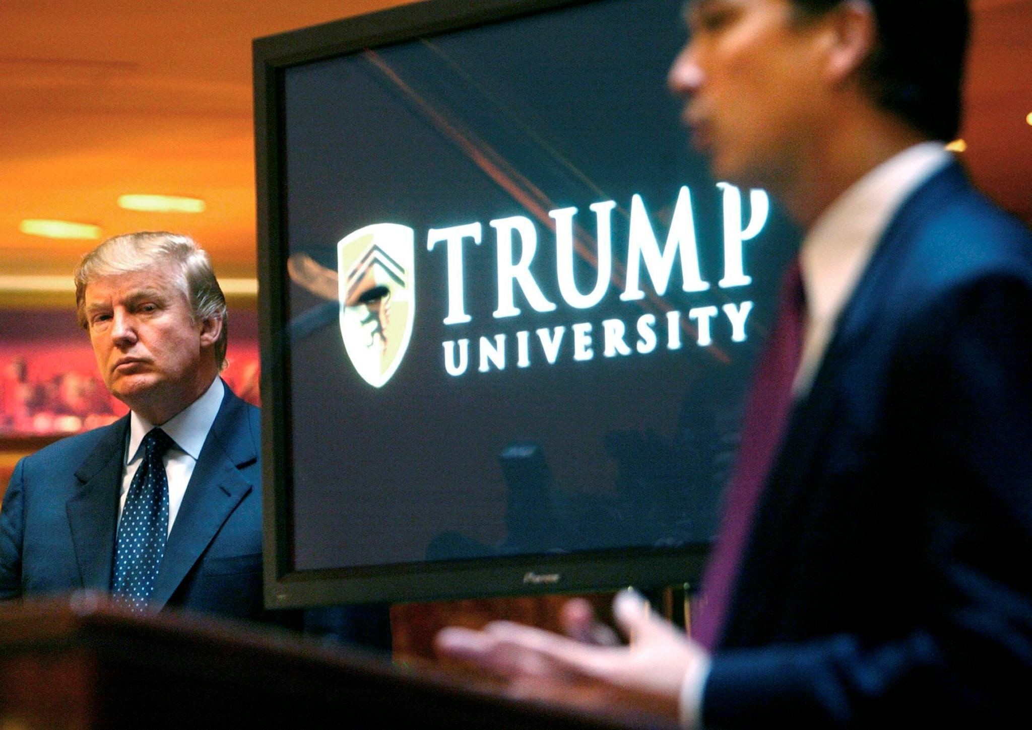 Donald Trump, left, listens as Michael Sexton introduces him at a news conference in New York where he announced the establishment of Trump University. (AP Photo)