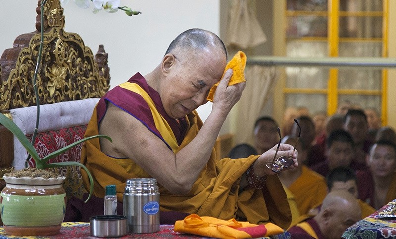 Tibetan spiritual leader the Dalai Lama wipes his brow before leading a prayer session in Dharmsala, India, Monday, May 16, 2016 (AP Photo)