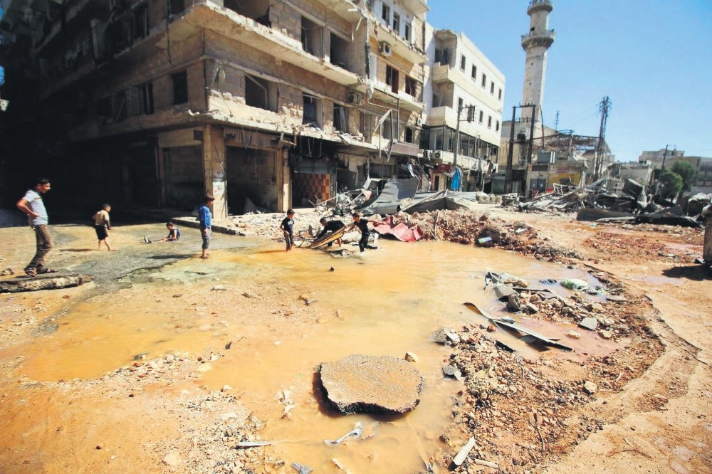 Children play with water from a burst water pipe at a site hit by an airstrike in Aleppo's opposition-controlled al-Mashad neighborhood, Syria, Sept. 30.