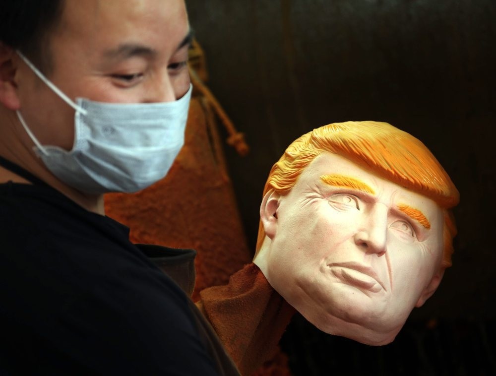 A man works on latex masks of U.S. presidential candidate Donald Trump at a factory in Pujiang county in east China's Zhejiang province. Orders for Donald Trump and Hilary Clinton masks have both exceed 500,000 pieces from the factory.