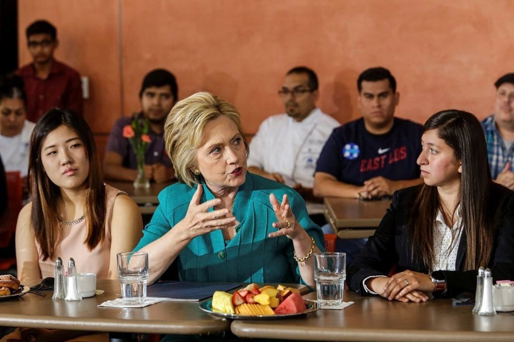 Democratic presidential candidate Hillary Clinton (C) holds a conversation on immigration.