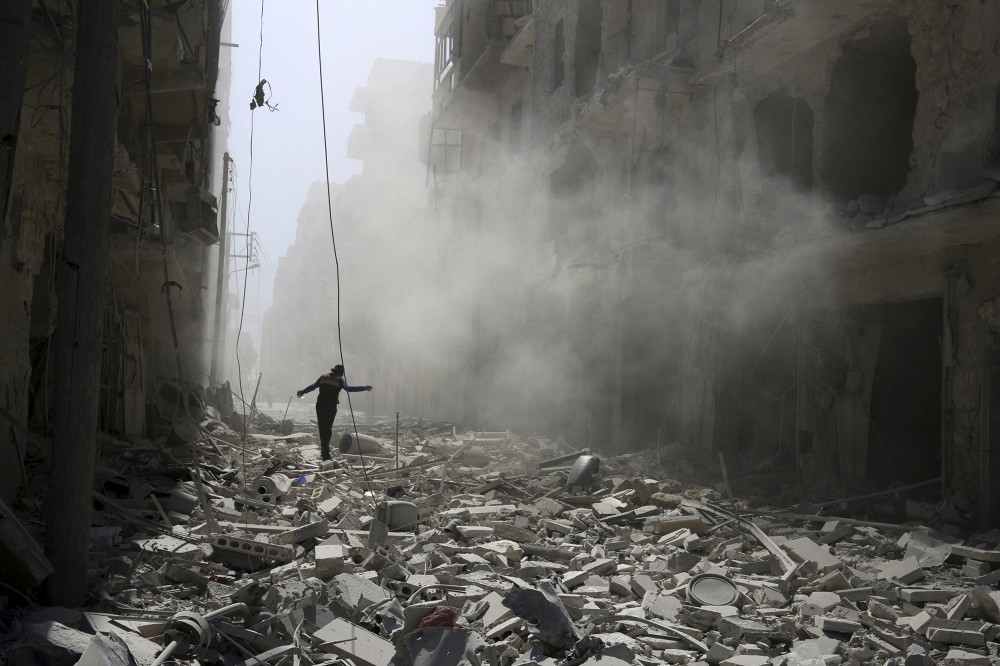 A man walking on the rubble of damaged buildings after an airstrike on the moderate-held al-Qaterji neighborhood of Aleppo, Syria, Sept. 25, 2016.