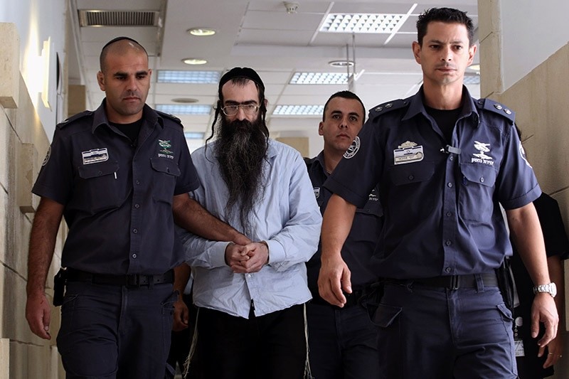 Ultra-Orthodox Jew Yishai Shlissel (C), who was convicted of killing a 16-year-old Israeli girl during the Jerusalem Gay Pride parade last year, is escorted by policemen into the courtroom, on June 26, 2016 (AFP Photo)