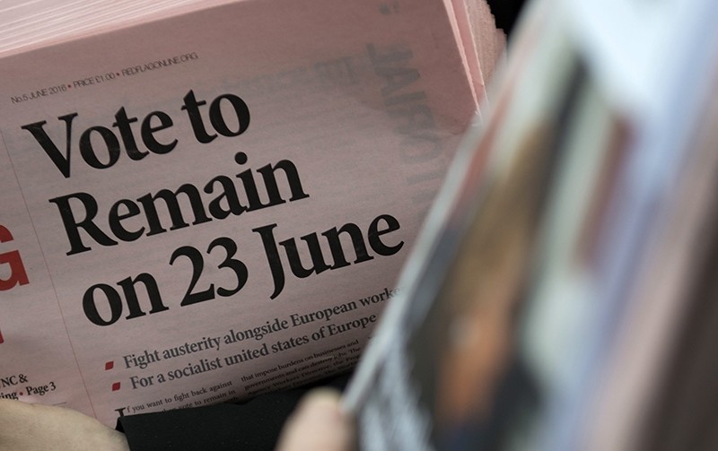A participant holds a newspaper showing 'Vote to Remain on 23 June' headline as members of the public take part in a 'Remain In' Rally in Trafalgar Square, Central London, Britain (EPA Photo)