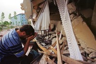 An earthquake survivor weeps next to his destroyed house in the western town of Seymen, u0130zmit in 1999.