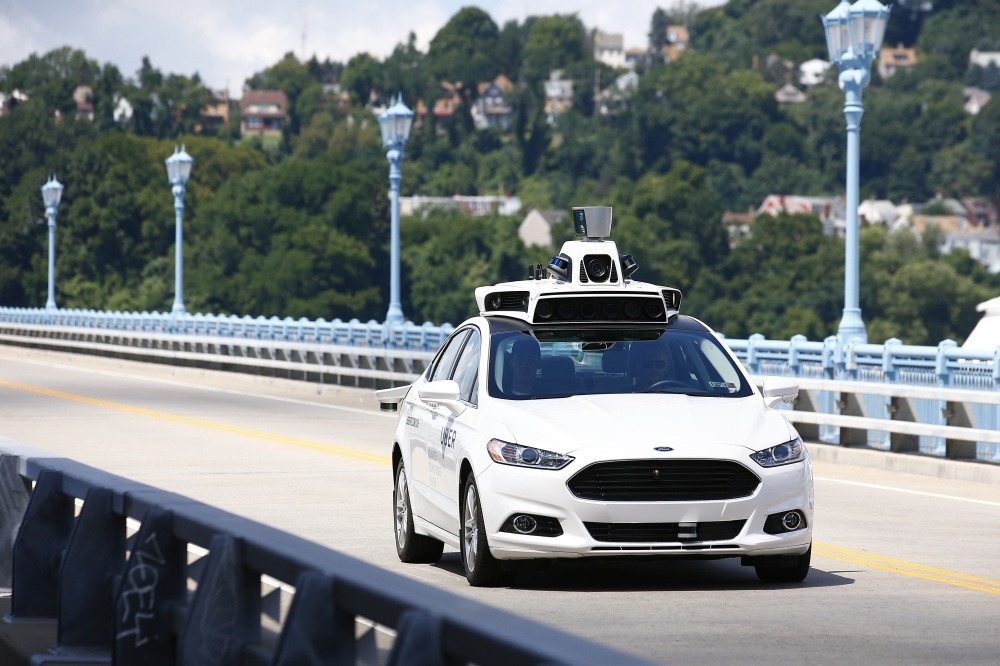 Uber employees test a self-driving Ford Fusion hybrid car in Pittsburgh. (AP Photo)
