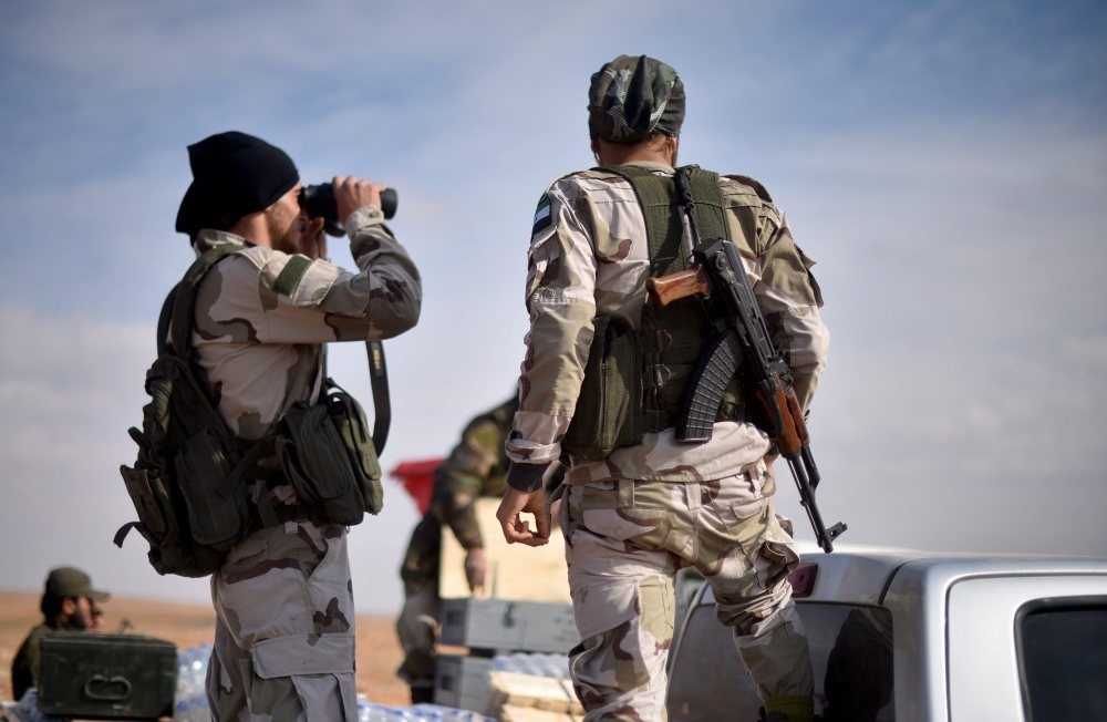 FSA fighters look through binoculars at Daesh targets in Qabasin village, near al Bab on Nov 19.