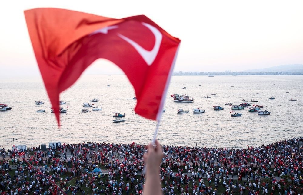 A person waves a Turkish flag during a rally at Gu00fcndou011fdu Square in u0130zmir to protest against the failed July 15 failed coup attempt. (AFP Photo)