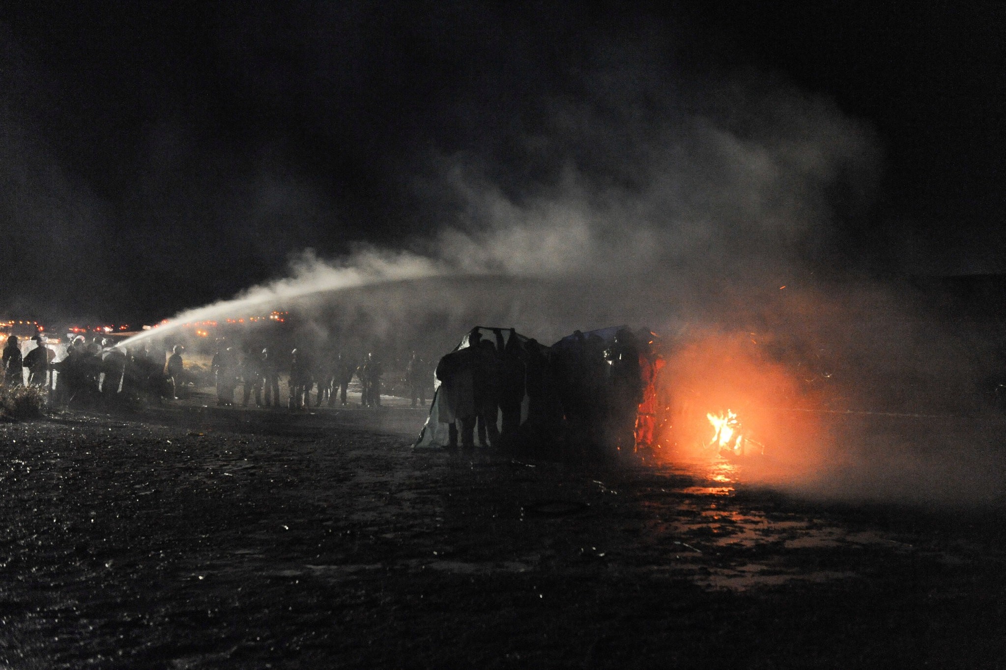 Police use a water cannon to put out a fire started by protesters during a protest against plans to pass the Dakota Access pipeline near the Standing Rock Indian Reservation. (REUTERS Photo)