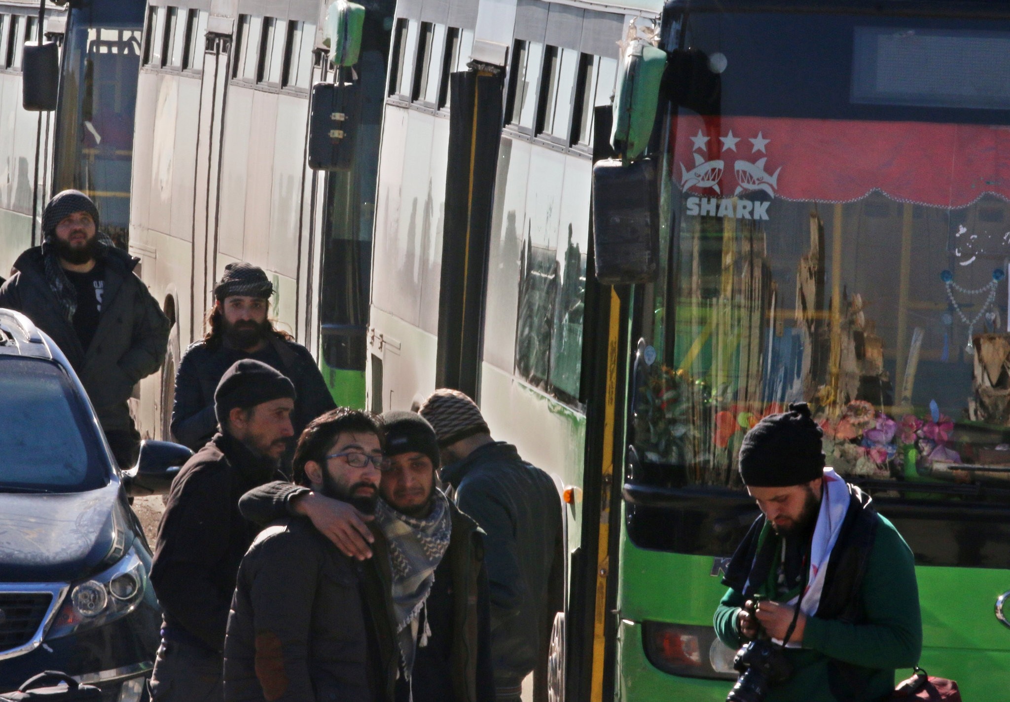 Men react as they stand outside buses evacuating people from a opposition-held sector of eastern Aleppo, Syria December 15, 2016. (REUTERS Photo)