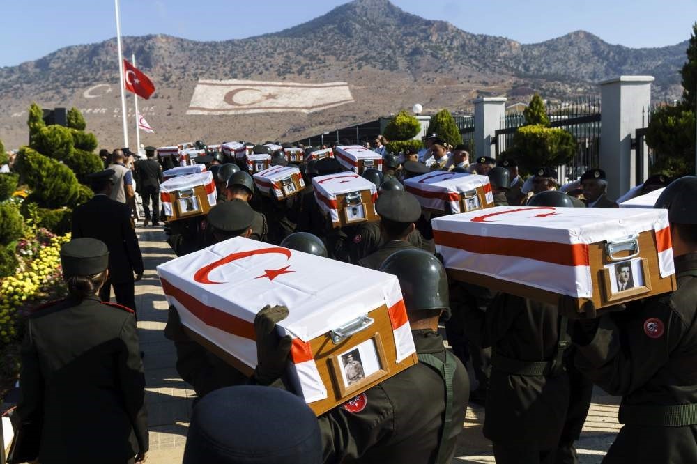 Soldiers carry coffins with remains of 33 villagers.