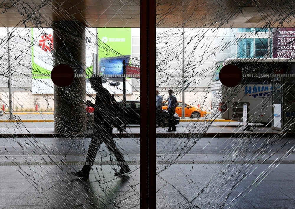 A man walks behind shattered glass at Istanbul's Atatu00fcrk International Airport, following Tuesday's blast, June 29.