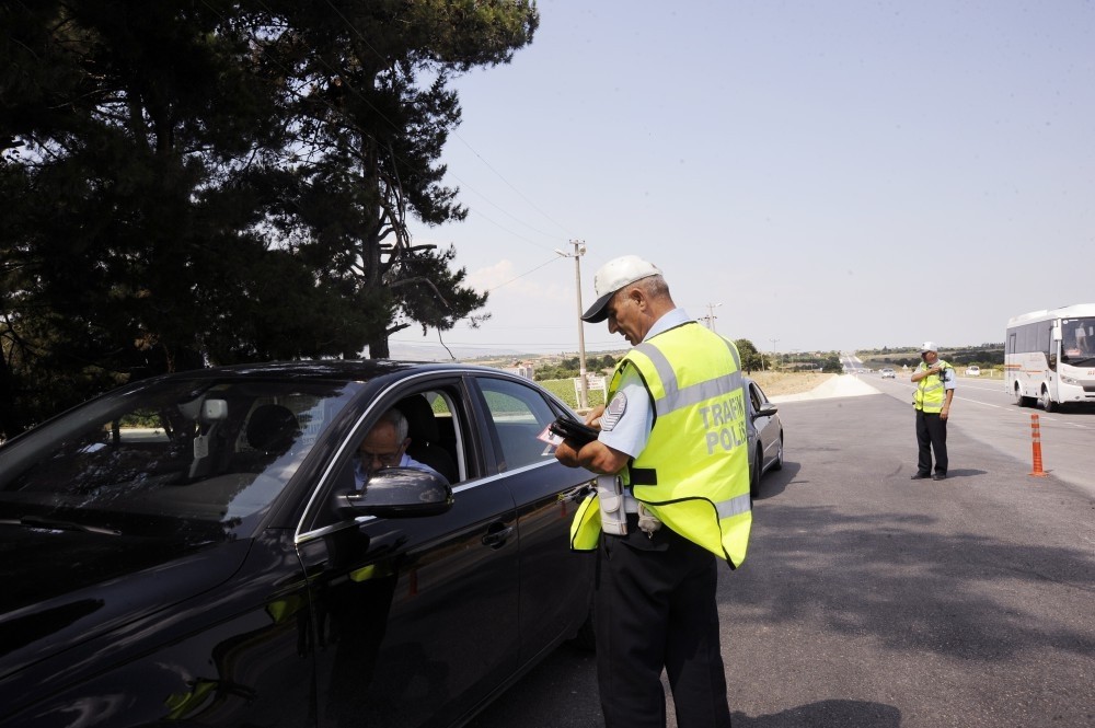 An officer checks the papers of a driver on a road in u00c7anakkale. The route is popular among holidaymakers from big cities in the west and often sees serious accidents.