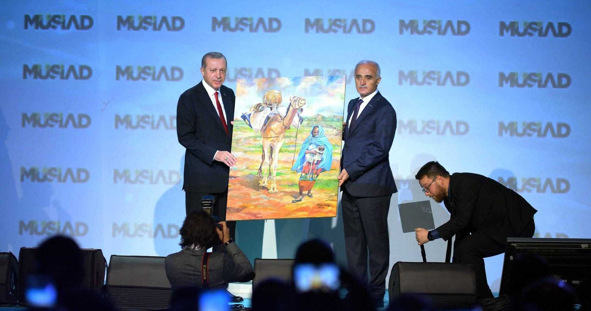Mu00dcSu0130AD Chairman Nail Olpak (R) presents an African artistu2019s painting to President Erdou011fan.