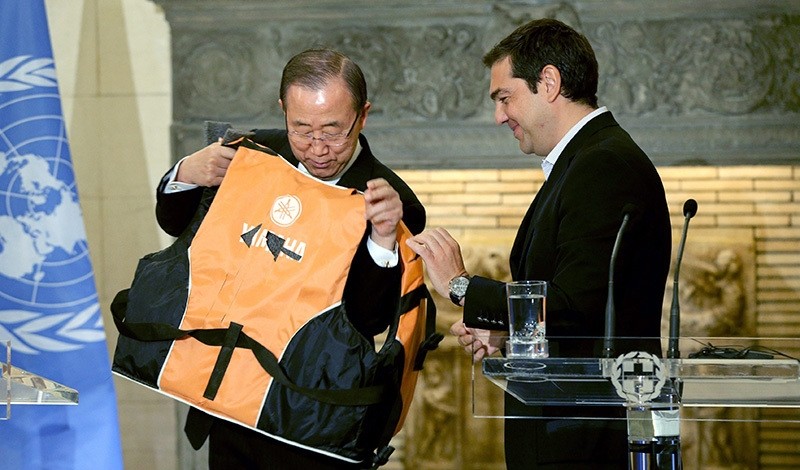 Greek Prime Minister Alexis Tsipras (R) gives United Nations (UN) Secretary General Ban Ki-moon a life vest to try on during their meetin at Maximos Mansion in Athens, Greece, 18 June 2016 (EPA Photo)