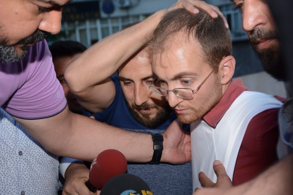 Police officers escort Atalay Filiz as he is brought to a police station.